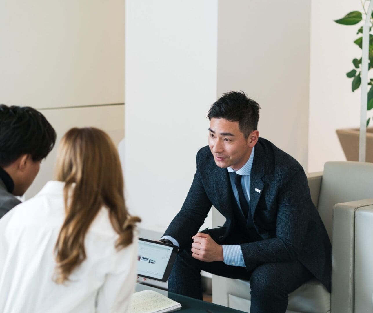 Business meeting with three people discussing.